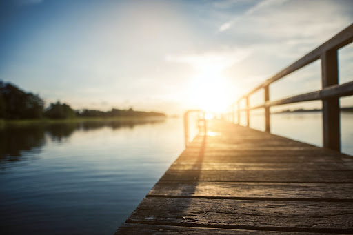 lakeside view at sunset Iron railings on a wooden deck.